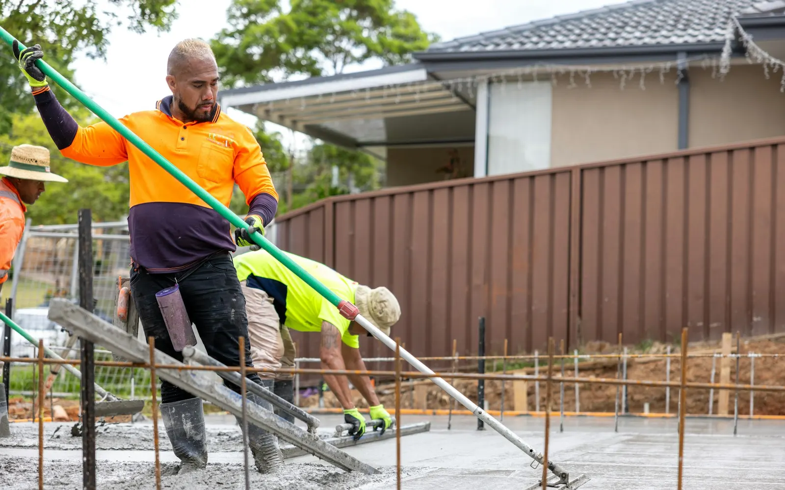 Workers smoothing fresh concrete on a new slab.